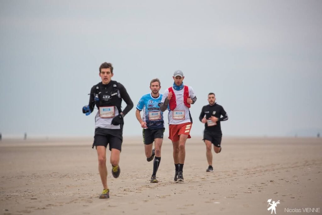 Groupe de traileurs sur la plage en train de courir