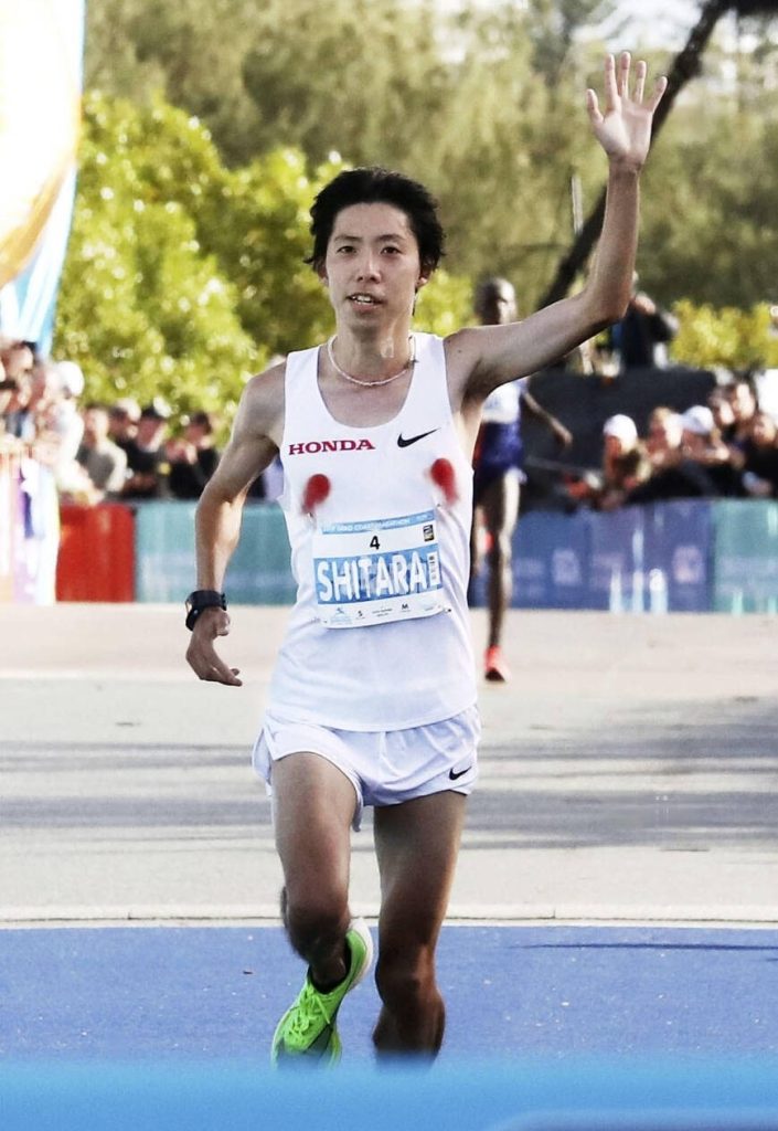 Shitara à la fin d'un marathon avec des taches rouges t-shirt mamelon du coureur