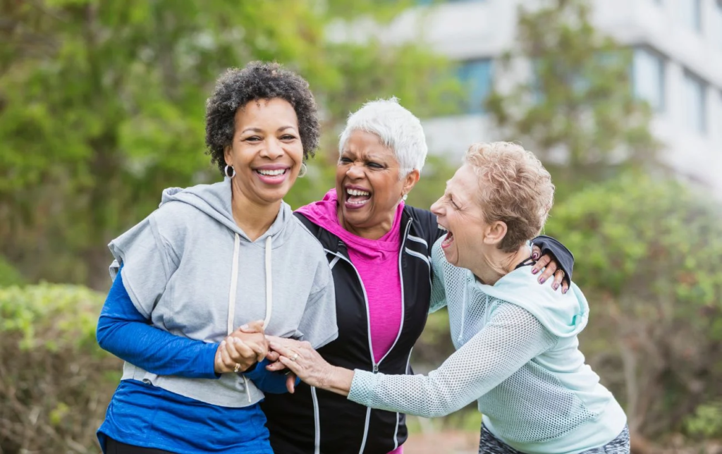 3 coureuses âgées souriantes se serrent la main