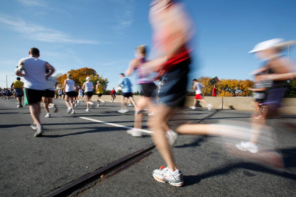 Plusieurs coureurs pendant une compétition running sur route avec des super chaussures