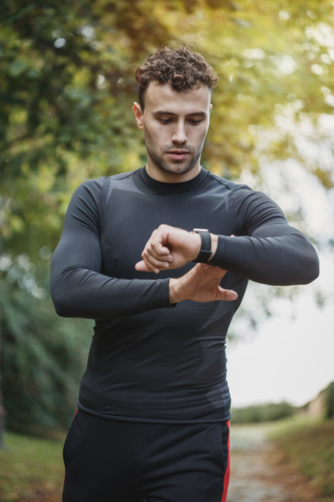 Un coureur immobile regarde sa montre GPS