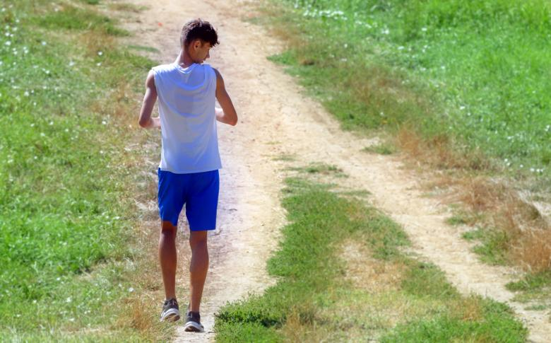 Jeune coureur masculin vue de dos regarde au sol