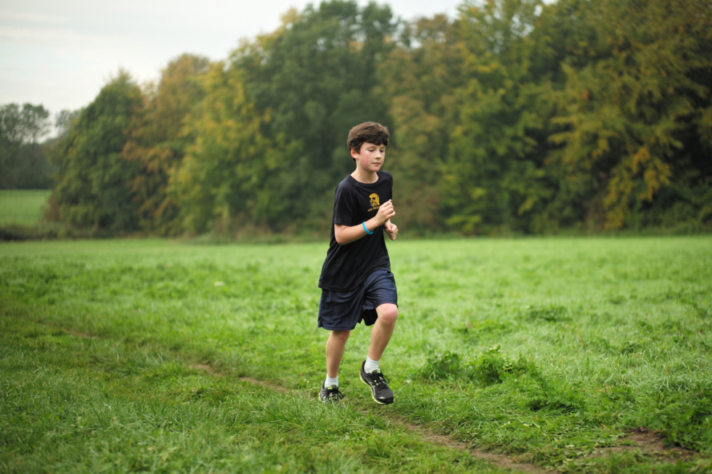 Jeune garçon court dans l'herbe