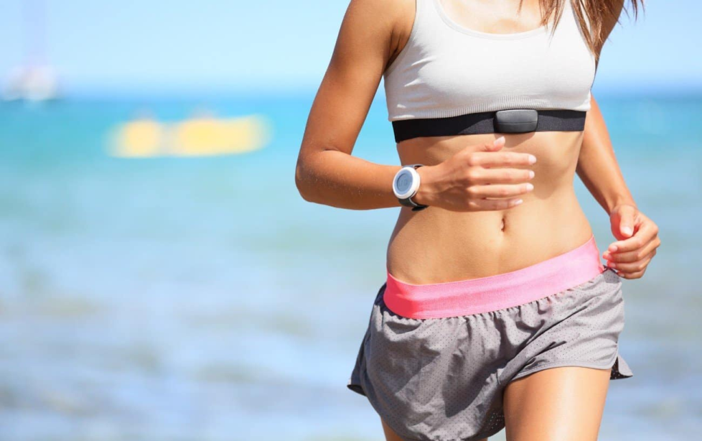 Une femme court avec une ceinture cardio