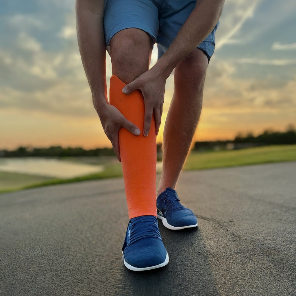Un coureur se tient la jambe avec les 2 mains