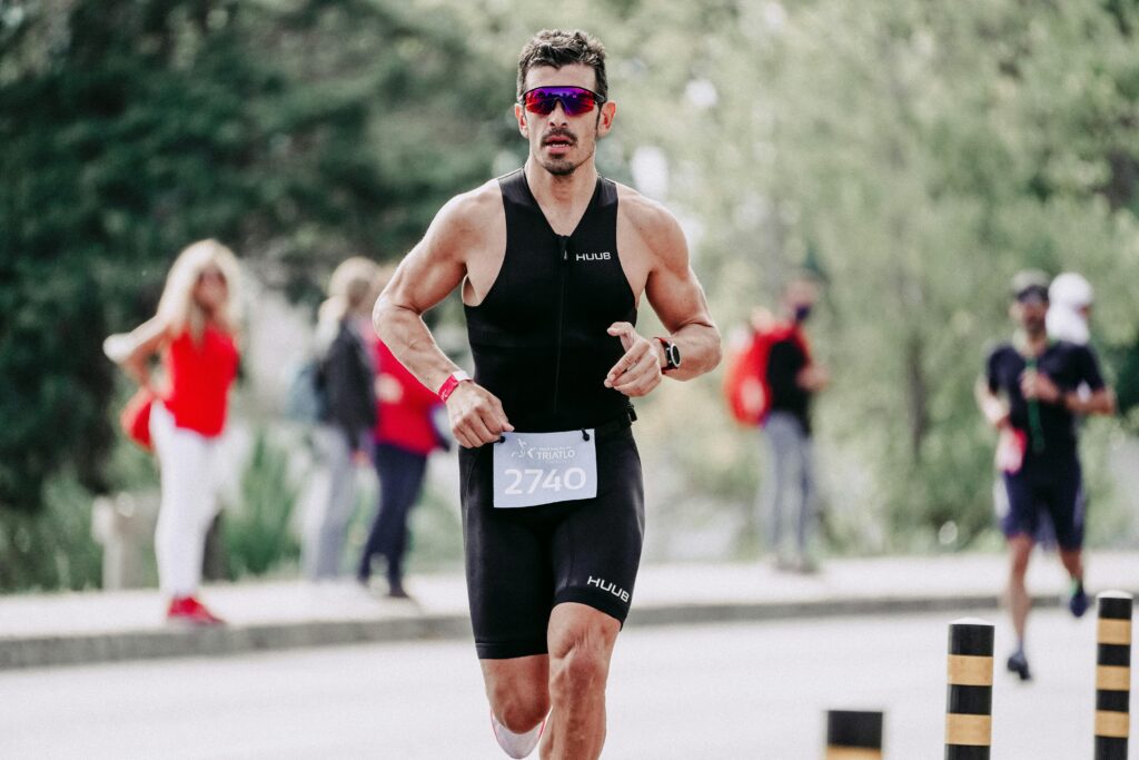 Un homme court avec des lunettes de soleil pendant une compétition running