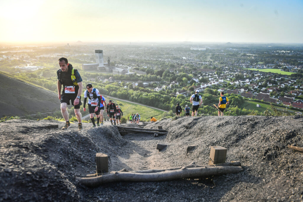 Des traileurs courent sur un terril pendant le trail des pyramides noires