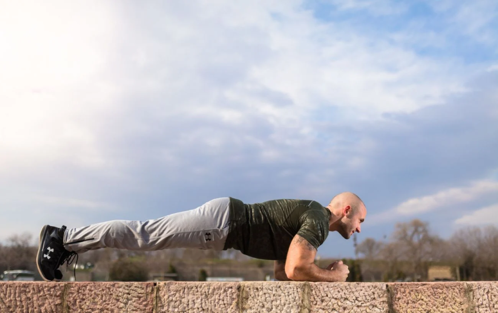 Un homme fait la planche dans un parc