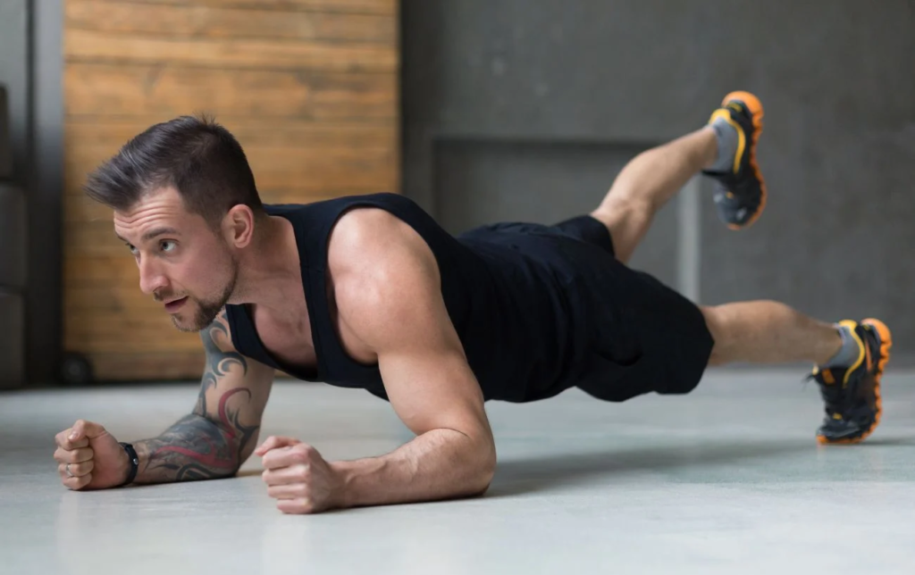 Un homme fait la planche avec une jambe levée