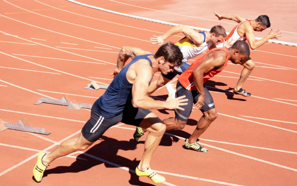 Des coureurs au départ d'un départ de 100 mètres sur une piste d'athlétisme