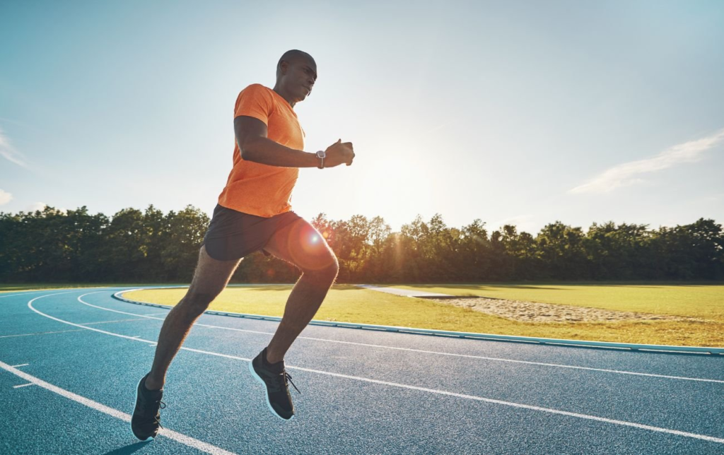 Un homme africain court sur une piste d'athlétisme