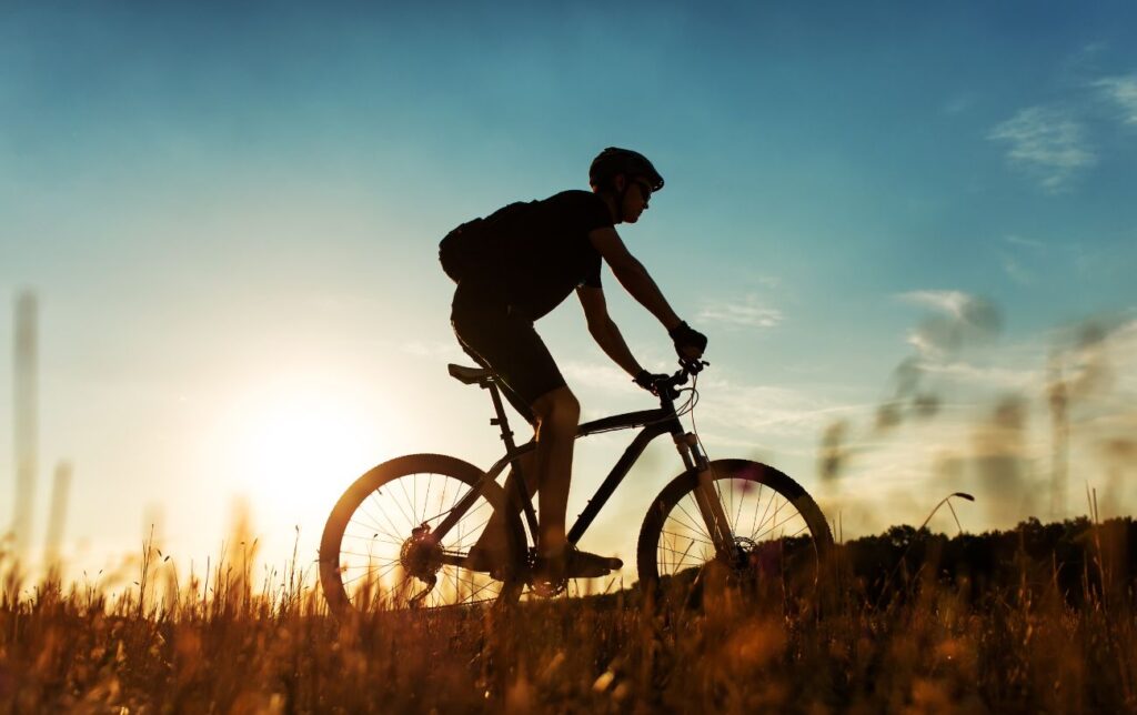 Un homme fait du VTT au coucher du soleil