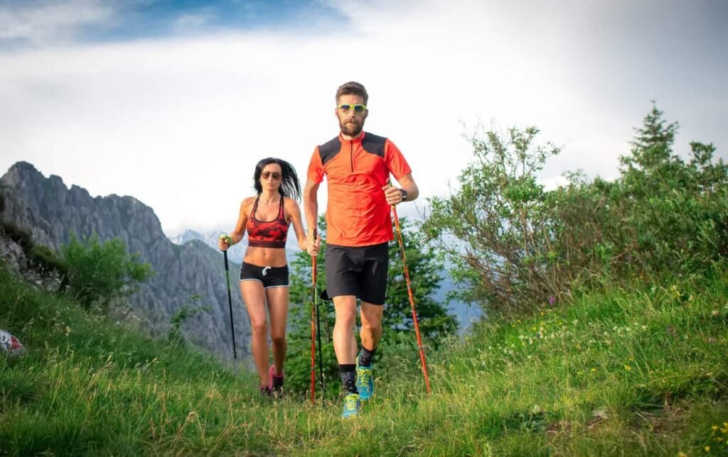 Un couple de traileurs avec des bâtons court en montagne