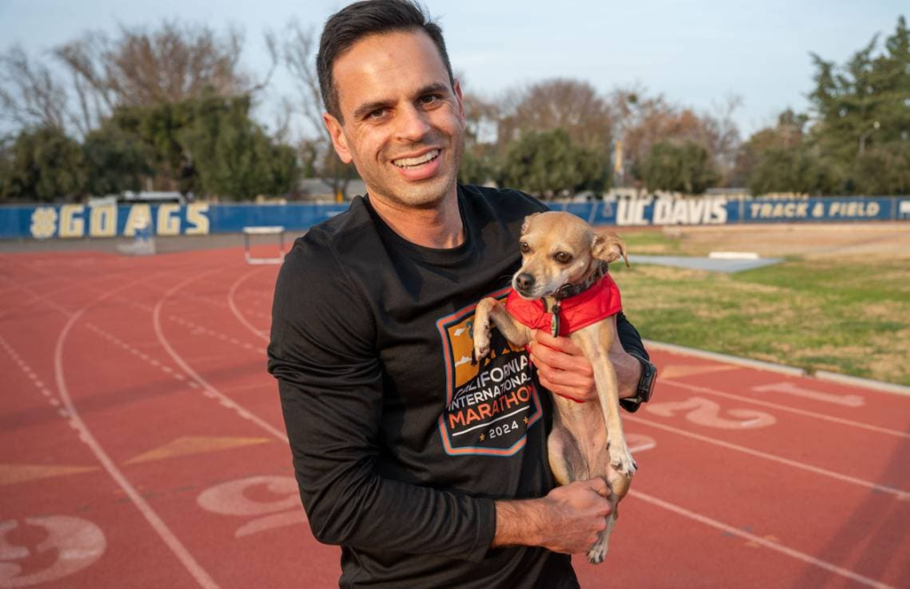 Chihuahua Jellybean port&eacute;e par son maitre Andrew Owens sur une piste d'athl&eacute;tisme